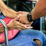 man holding hand with woman on chair